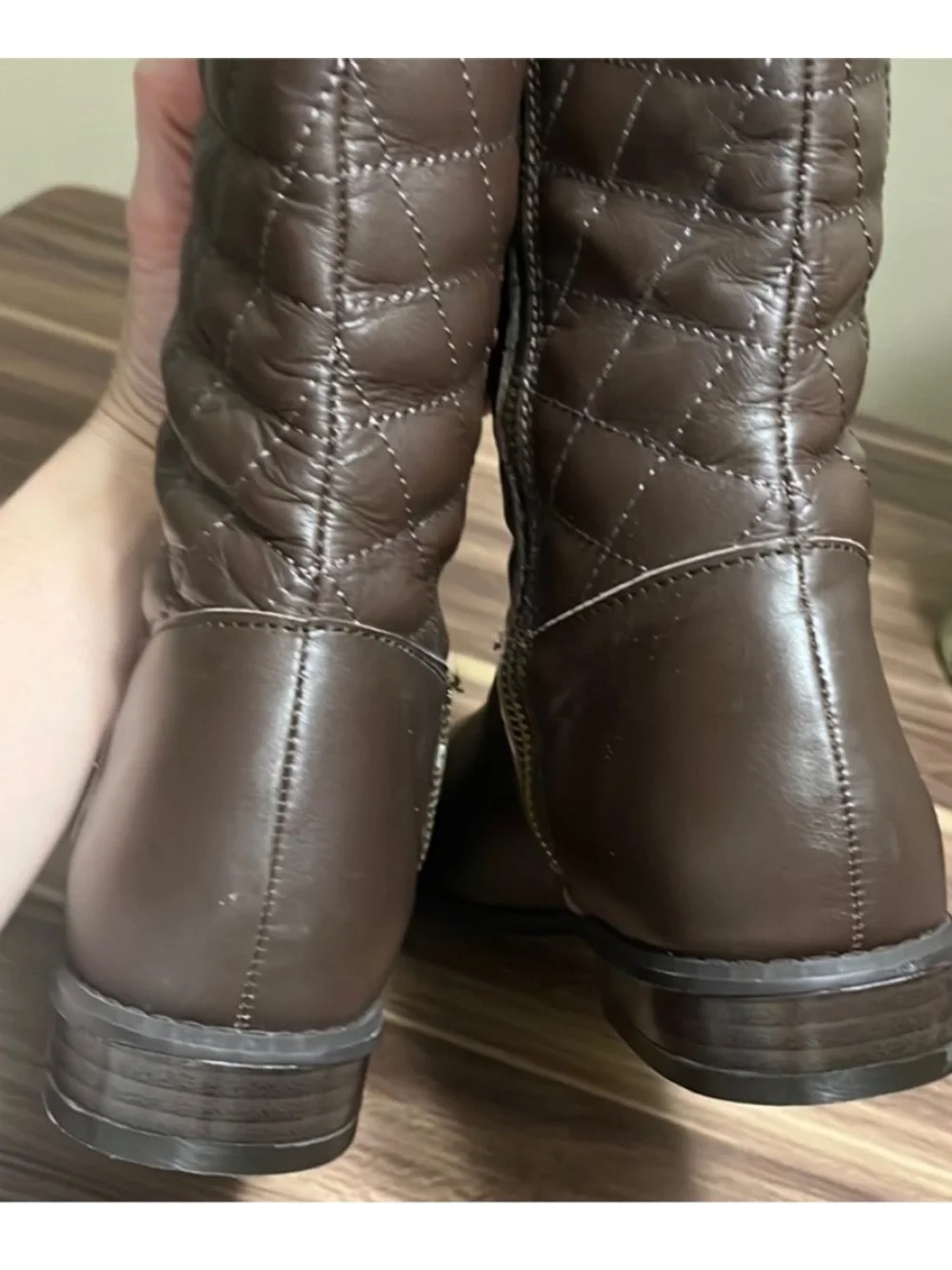 Iman Brown Quilted Knee-High Riding Boots with gold logo medallion